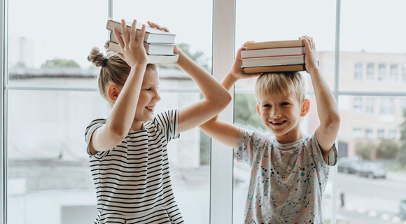 Children balancing books on head